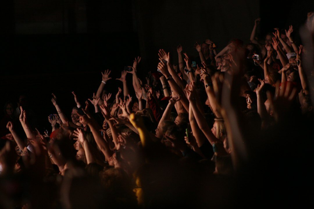 Crowd of fans with raised hands at a live music concert